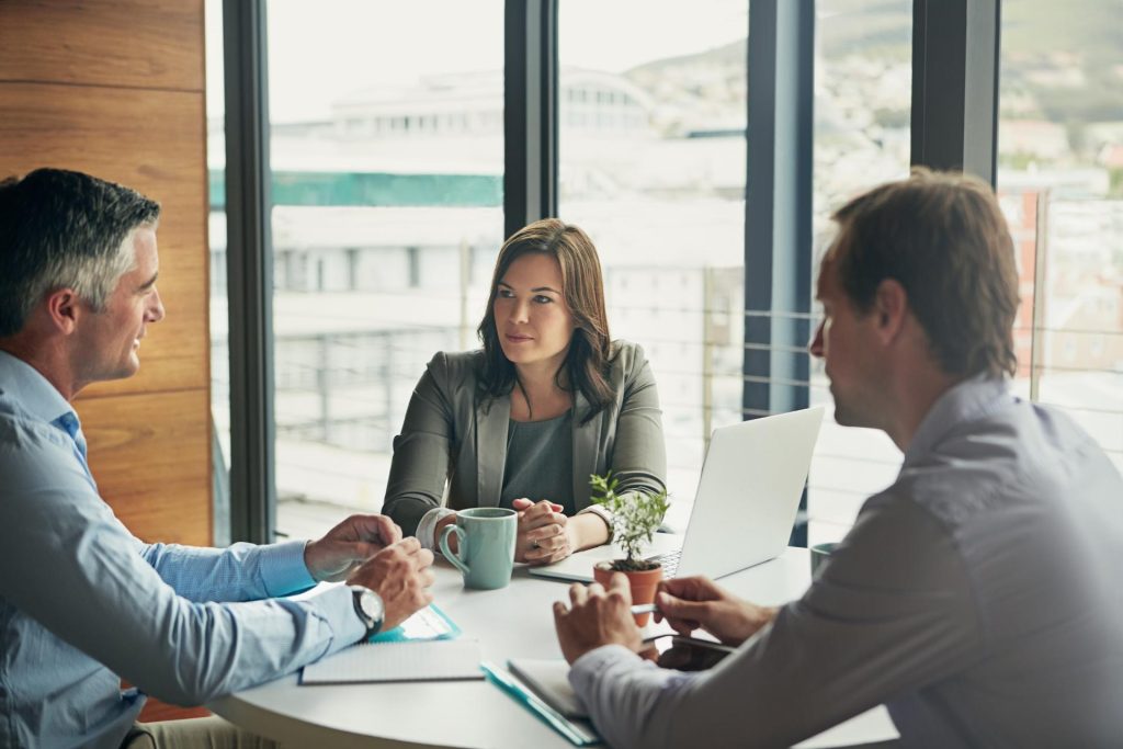Dos hombres y una mujer en una reunión